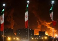Foto: Bendera Iran berkibar saat api dan asap dari serangan Israel terhadap depot minyak Sharan membubung, menyusul serangan Israel terhadap Iran, di Teheran, Iran, 15 Juni 2025. (via REUTERS/Majid Asgaripour)